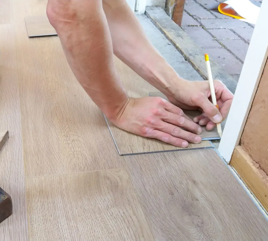 Carpintero midiendo un suelo de madera