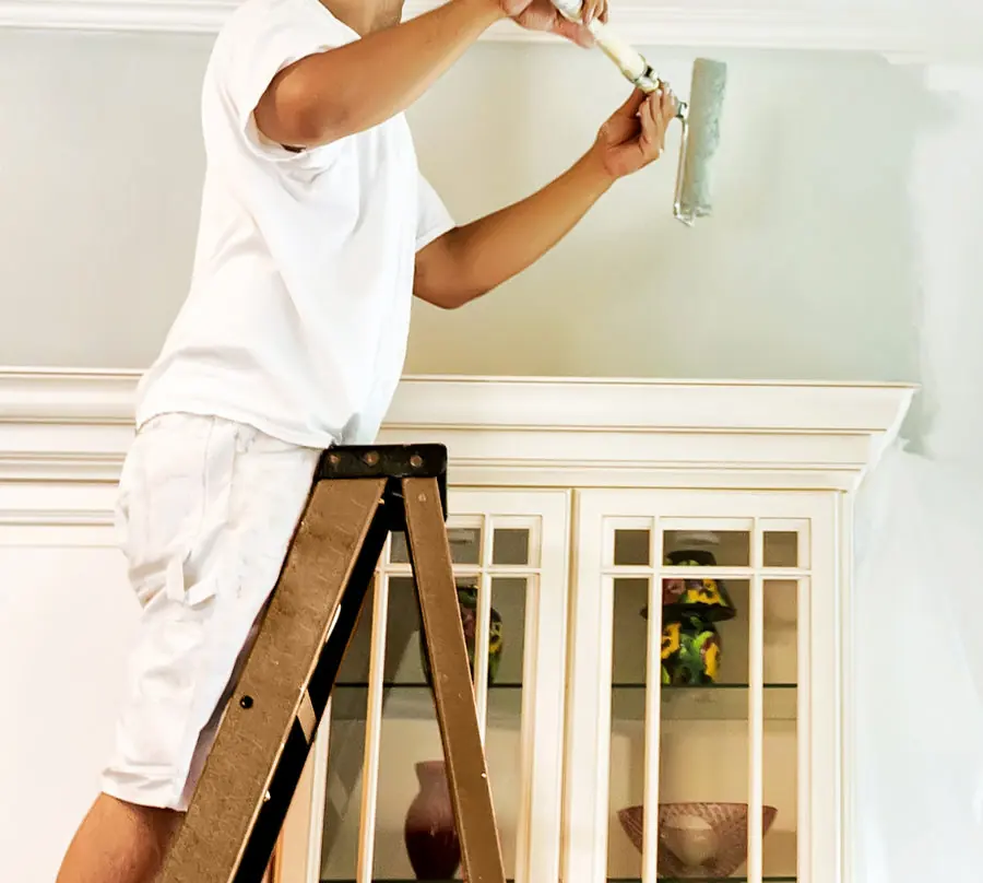 Pintor pintando una pared interior en blanco
