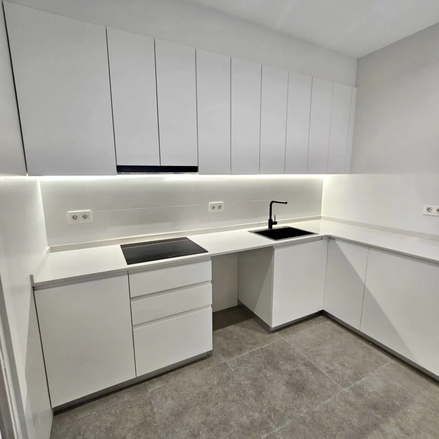 Cocina reformada en blanco con los electrodomésticos integrados en columnas